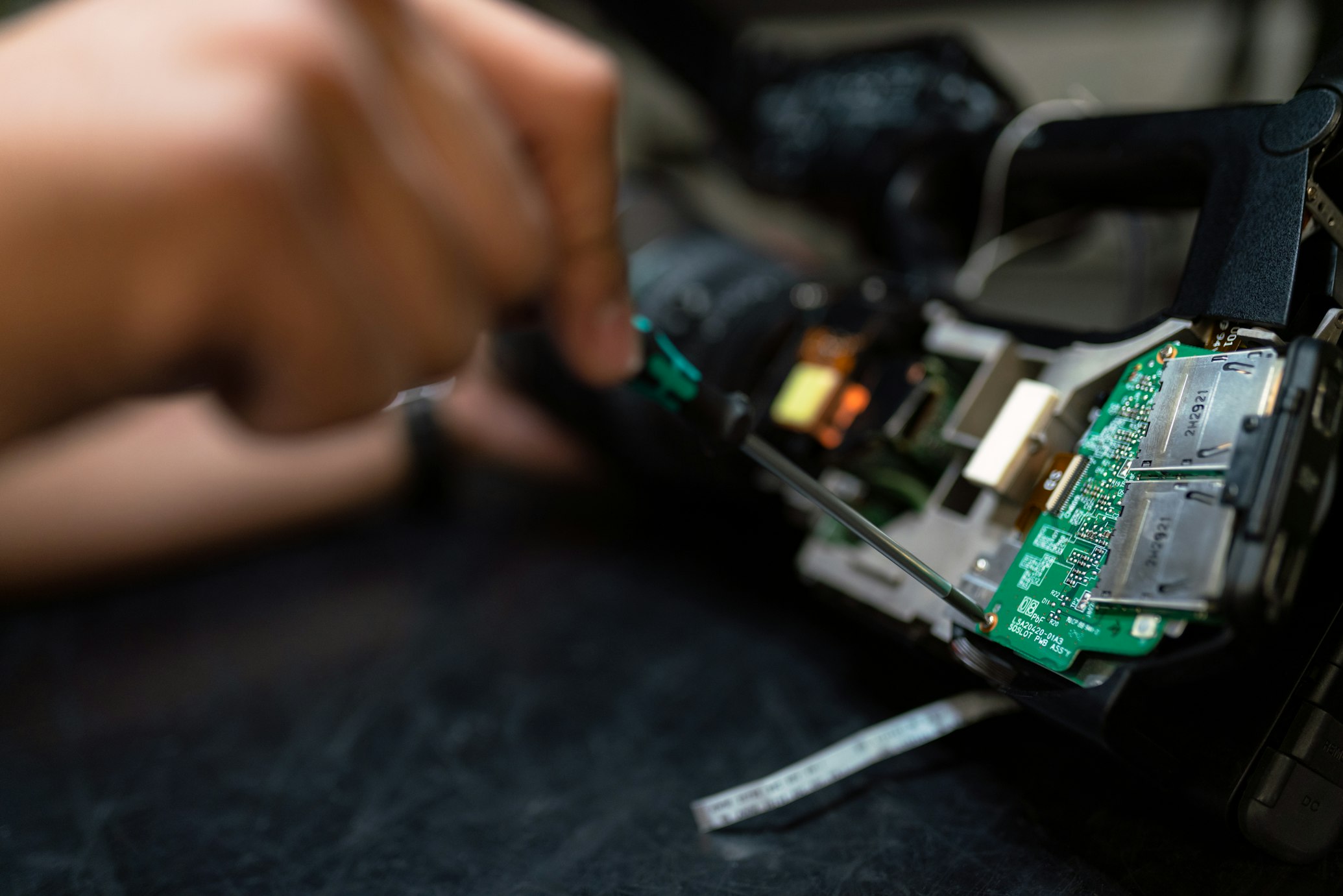 Cinematic close-up of technician hands in black nitrile gloves repairing a refrigerator component on a dark tiled floor with professional tools nearby